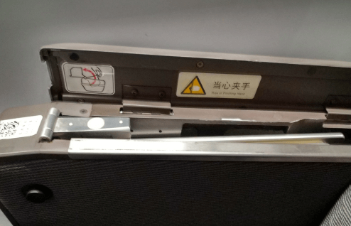 開蓋后可以看到一塊金屬板，這個就是藏起來的高鐵小桌板，向上將其拉出。